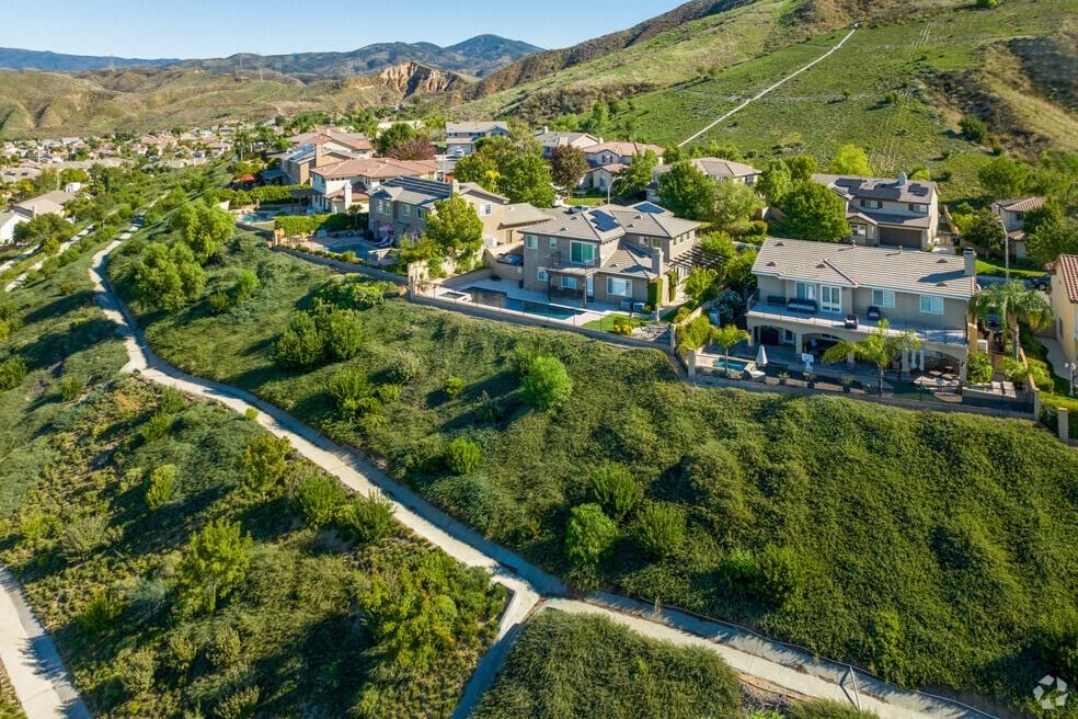 Aerial view of hillside homes above green trails and canyons in Saugus, Santa Clarita, California